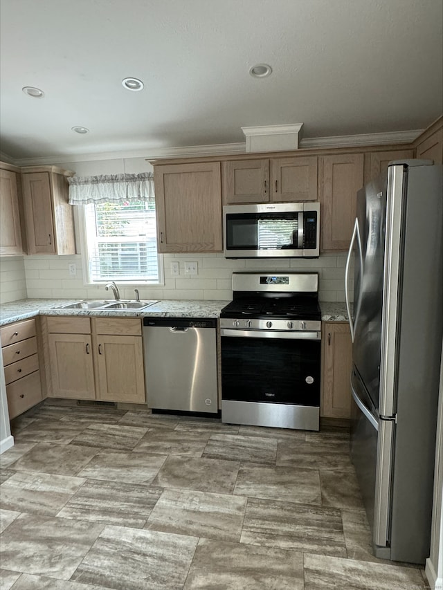 kitchen with light brown cabinets, appliances with stainless steel finishes, backsplash, and a sink