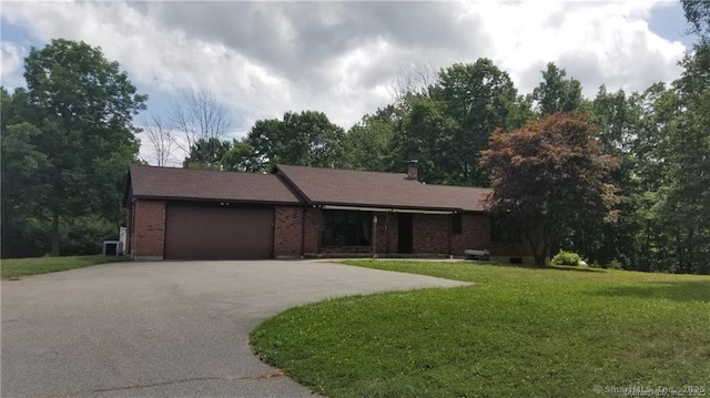 ranch-style house with an attached garage, brick siding, driveway, and a front lawn