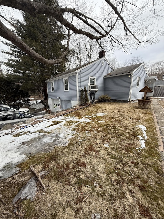 view of front of property featuring a garage, cooling unit, and a chimney