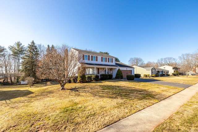 traditional-style house with driveway and a front lawn