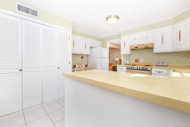 kitchen featuring visible vents, wall oven, under cabinet range hood, a peninsula, and freestanding refrigerator