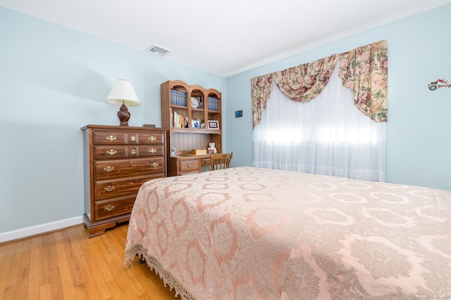 bedroom with baseboards, visible vents, and light wood-type flooring