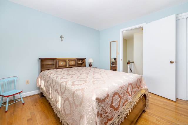 bedroom with light wood-style flooring and baseboards