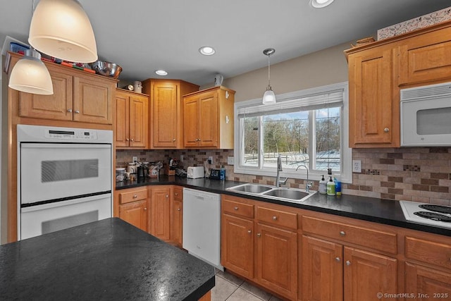 kitchen featuring a sink, white appliances, and dark countertops