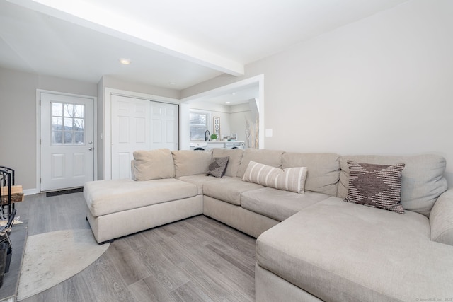 living room featuring recessed lighting, beamed ceiling, baseboards, and wood finished floors