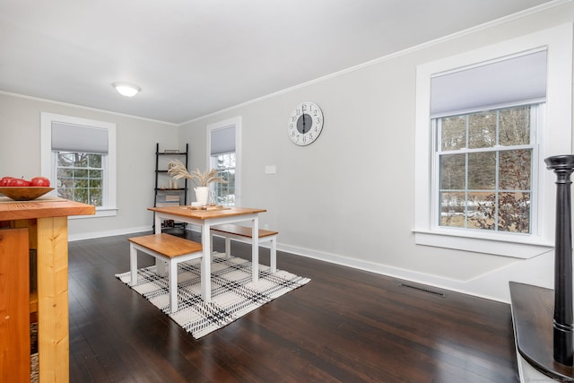 dining room featuring baseboards, visible vents, ornamental molding, and dark wood-type flooring