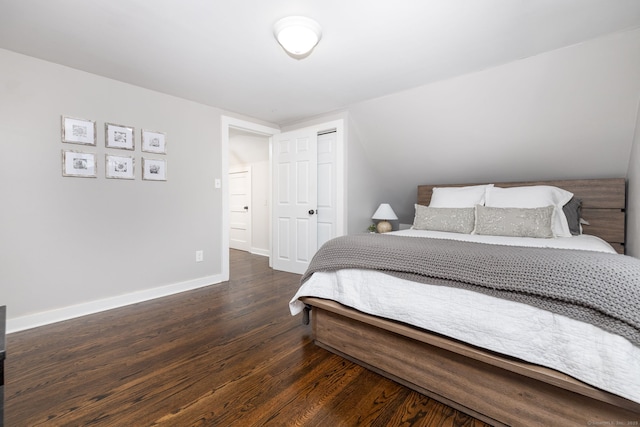 bedroom with a closet, wood finished floors, and baseboards