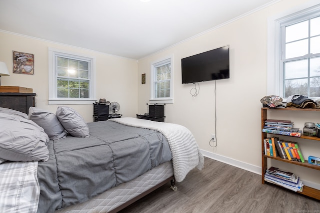 bedroom featuring multiple windows, wood finished floors, and crown molding