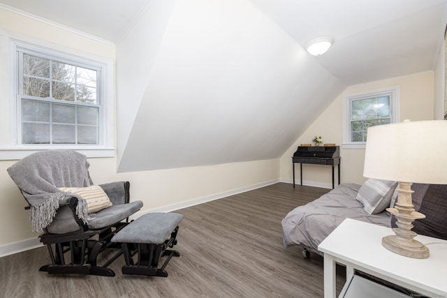 bedroom with lofted ceiling, crown molding, wood finished floors, and baseboards