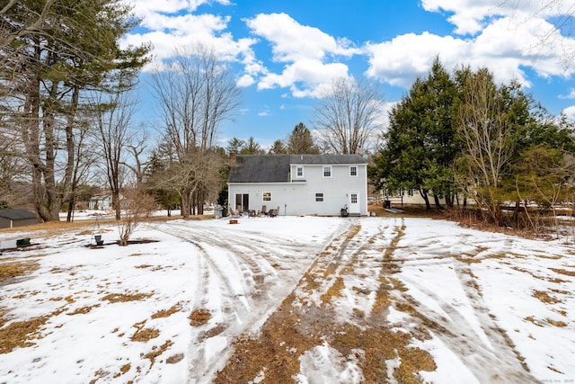 view of snow covered rear of property