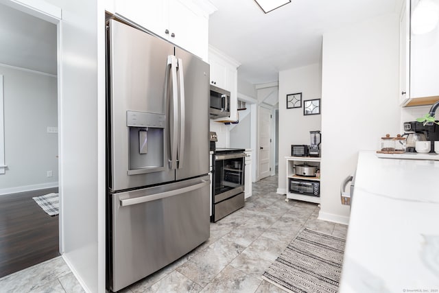 kitchen with baseboards, appliances with stainless steel finishes, white cabinets, and light countertops