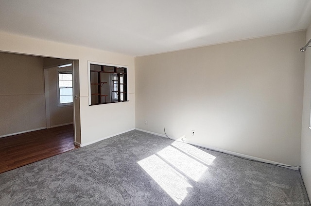 unfurnished room featuring carpet floors and baseboards