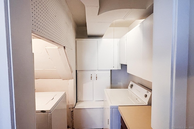 washroom featuring cabinet space and washer and clothes dryer