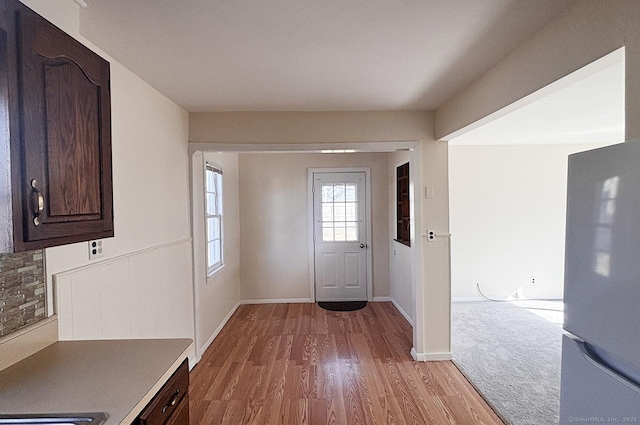 foyer with baseboards and wood finished floors