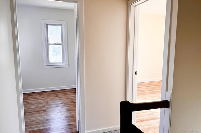 hall with baseboards and wood finished floors