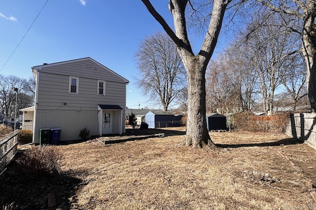 view of side of home featuring a shed, a fenced backyard, and an outdoor structure