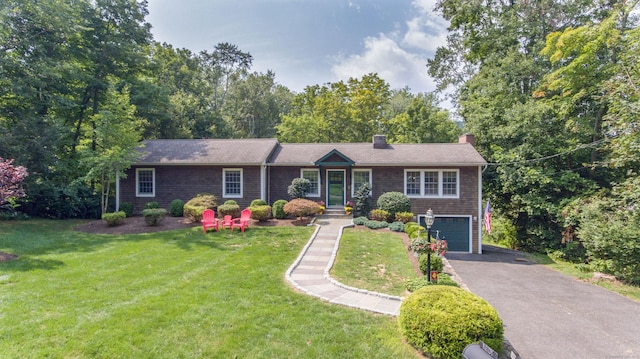 single story home with a garage, a front yard, a chimney, and driveway