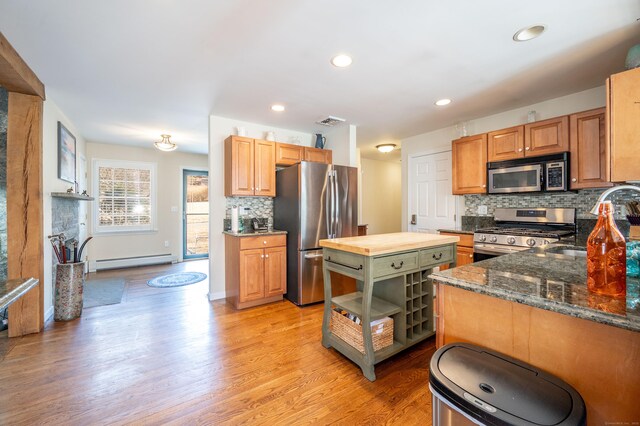 kitchen featuring visible vents, wooden counters, light wood finished floors, stainless steel appliances, and a baseboard heating unit