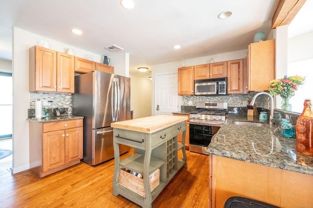 kitchen with visible vents, light wood-style flooring, a sink, butcher block countertops, and stainless steel appliances