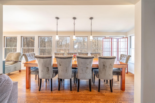 dining area featuring baseboards and light wood-style floors