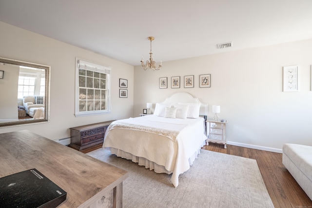 bedroom featuring wood finished floors, baseboards, visible vents, a baseboard radiator, and a chandelier