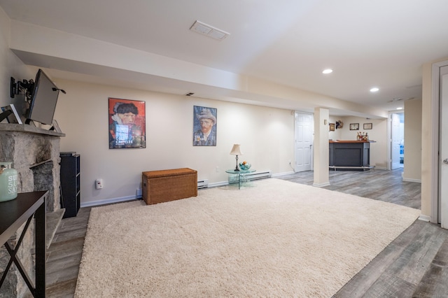 living area with wood finished floors, visible vents, baseboards, recessed lighting, and a baseboard heating unit