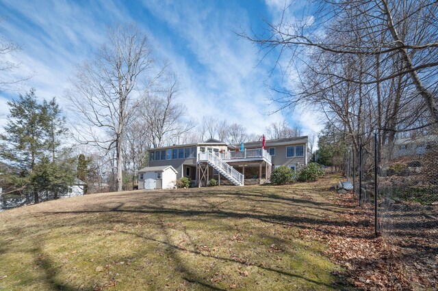 view of front of home with a front lawn, a deck, and stairs