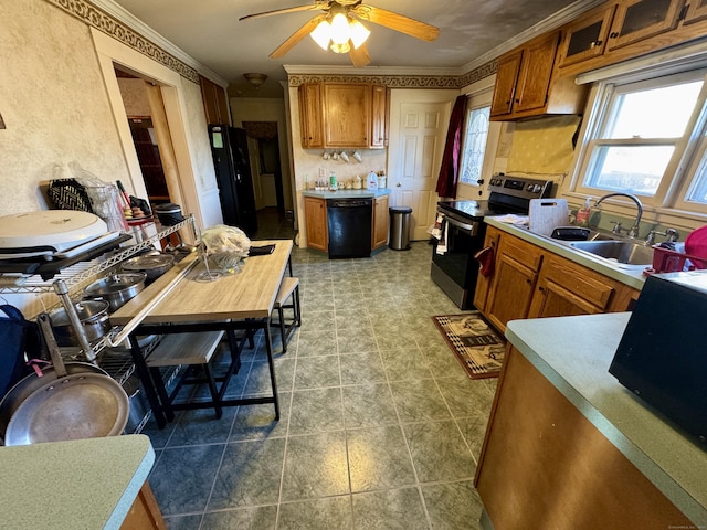 kitchen featuring brown cabinets, light countertops, ornamental molding, a sink, and black appliances