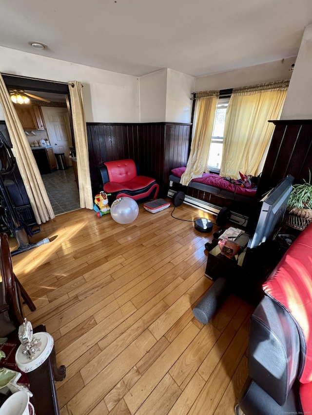 bedroom with hardwood / wood-style floors and wainscoting