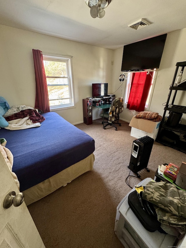 carpeted bedroom with visible vents and baseboards