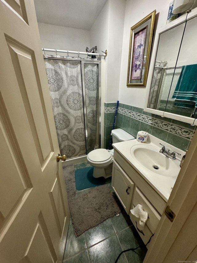 full bath featuring a stall shower, toilet, tile walls, and vanity