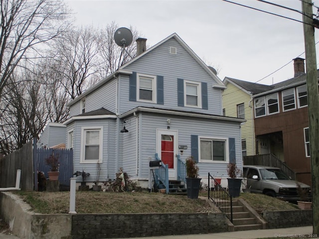 view of front of property featuring entry steps and fence