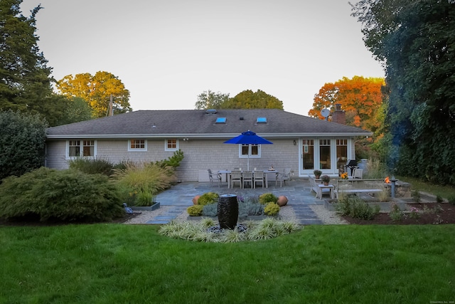 rear view of house with a yard, a chimney, and a patio