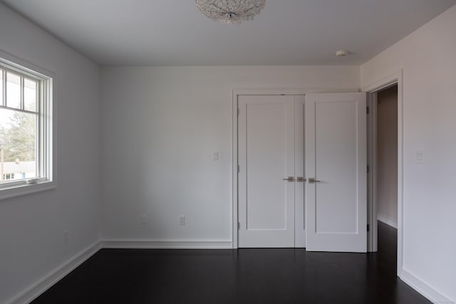 9 Schiller Rd, Fairfield, CT 06825 - unfurnished bedroom featuring a closet, dark wood-style floors, and baseboards