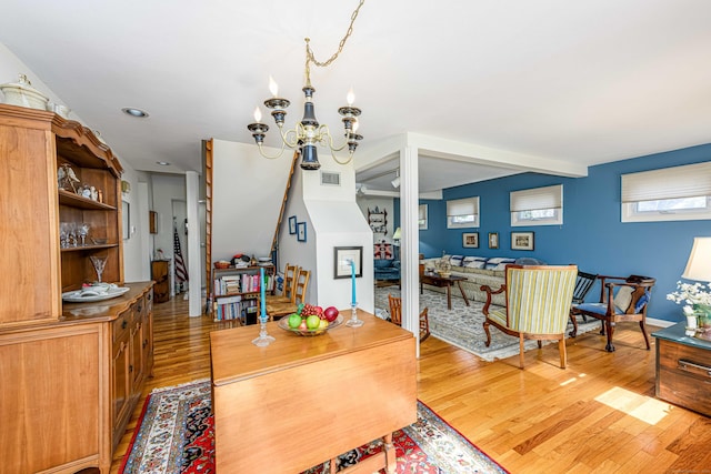 dining room with a chandelier, light wood-type flooring, and visible vents