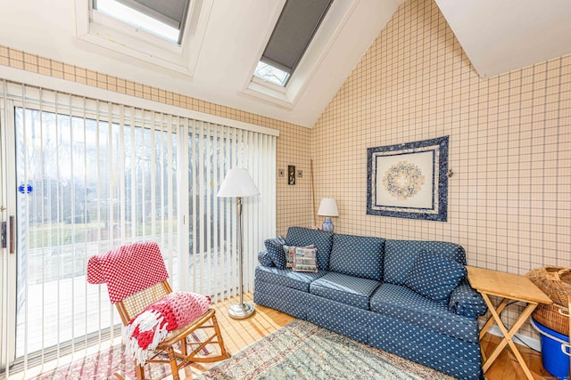 tiled living area with vaulted ceiling with skylight, tile walls, and a healthy amount of sunlight