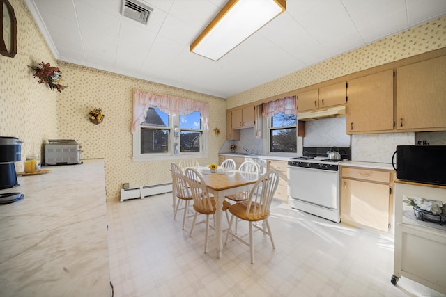 kitchen featuring under cabinet range hood, baseboard heating, light floors, gas range gas stove, and wallpapered walls