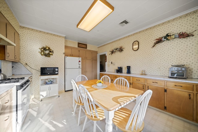 kitchen featuring wallpapered walls, white appliances, visible vents, light countertops, and light floors