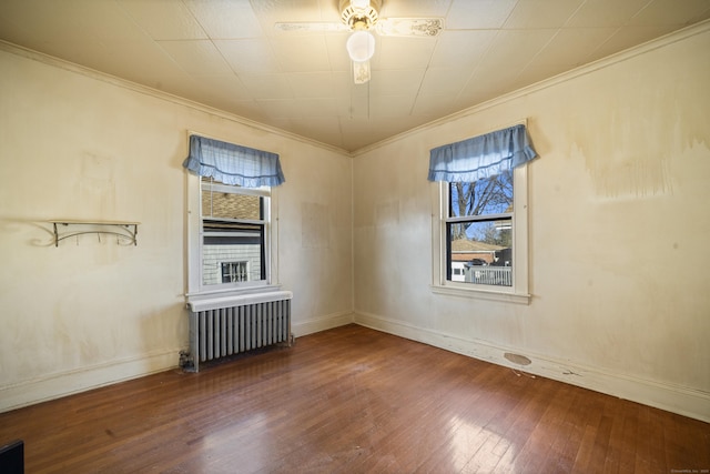 spare room featuring ornamental molding, radiator, and wood-type flooring