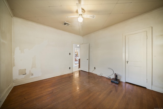 empty room featuring crown molding, visible vents, ceiling fan, and hardwood / wood-style flooring