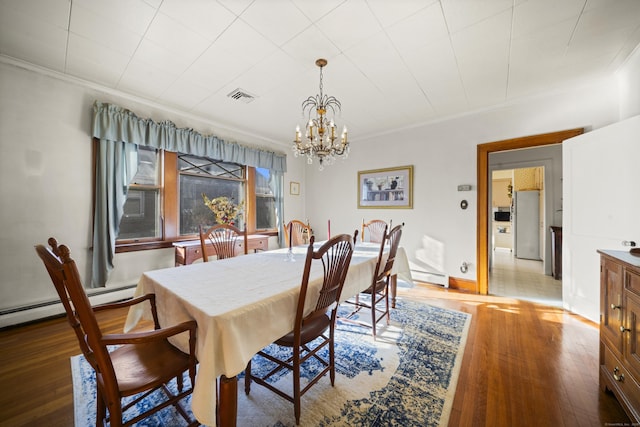 dining room with visible vents, a baseboard radiator, wood finished floors, crown molding, and a chandelier