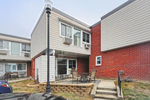 back of house with a patio area and brick siding