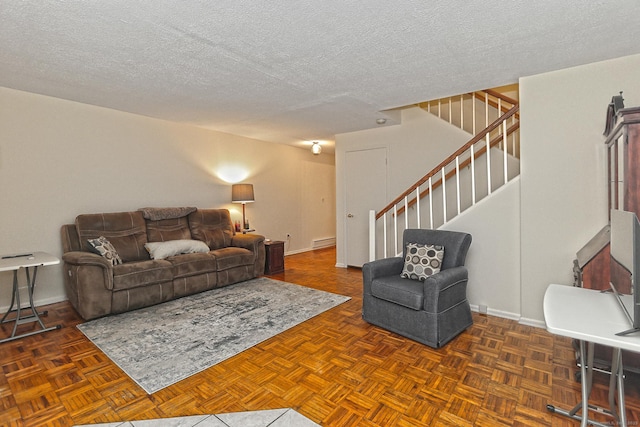 living area featuring stairs, a textured ceiling, and baseboards