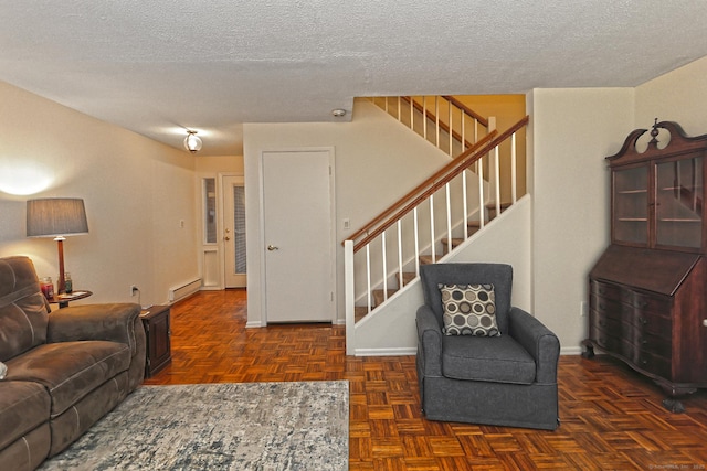 living area with a textured ceiling, stairway, and baseboard heating