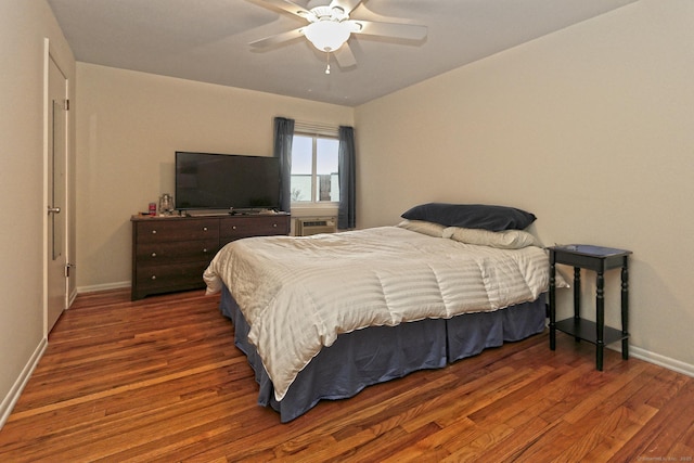 bedroom with ceiling fan, baseboards, and wood finished floors