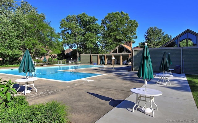 community pool featuring fence and a patio