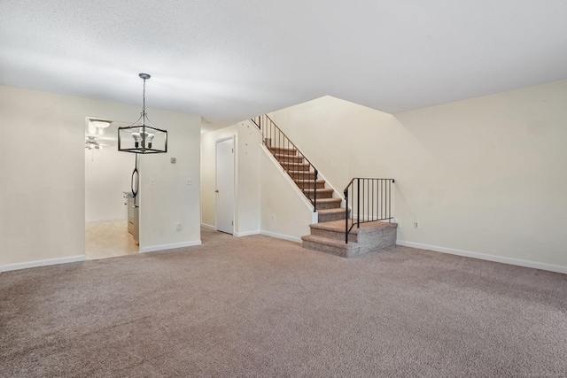 spare room with light carpet, stairway, a textured ceiling, and baseboards