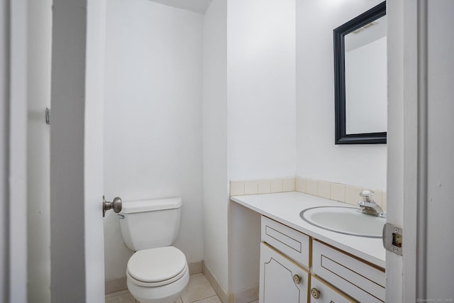 bathroom with toilet, tile patterned flooring, baseboards, and vanity