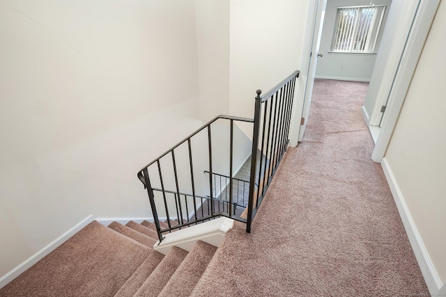 stairs featuring carpet flooring and baseboards