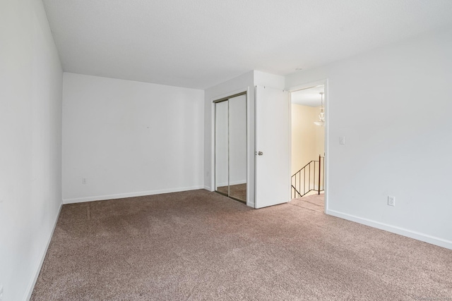 unfurnished bedroom featuring a closet, carpet flooring, and baseboards